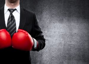 Businessmann mit roten Boxhandschuhen - Resilienz-Akademie