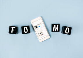 FOMO, Fear of missing out, social anxiety, stay continually connected, fear of regret, Social networking. FOMO text with cell phone with Clubhouse icons. Kropivnitskiy, Ukraine, March 20, 2021
