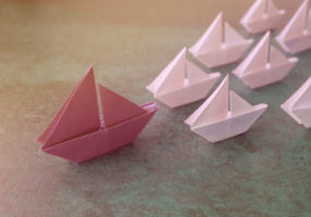 Origami paper sailboats, female woman leadership business concep